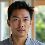 Marcus Chen, Head of Content at Veridian Bloom, a man in his early 40s with a thoughtful expression and approachable demeanor. He is in a bright, relaxed setting, perhaps a coffee shop or a modern co-working space, with a notebook visible.